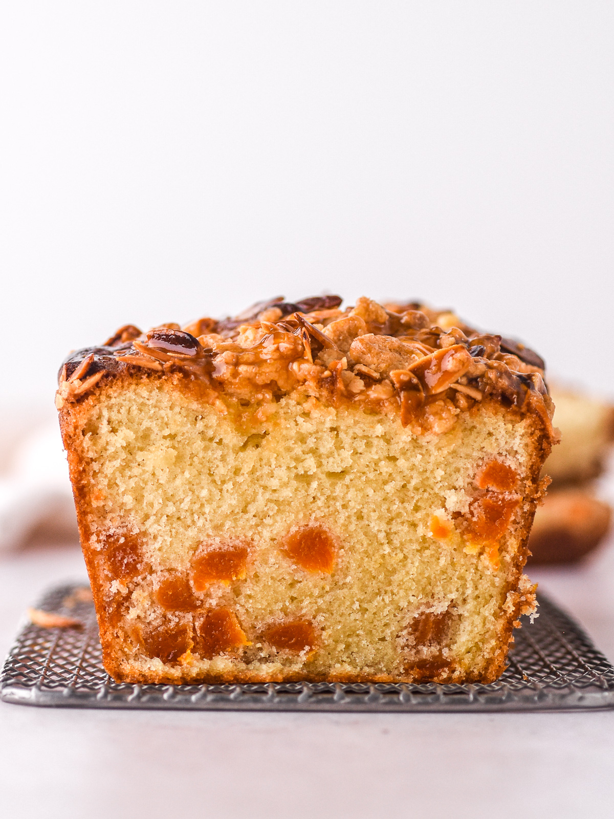 Image showing the inside of the loaf cake so that you can see the fluffy texture and the apricot pieces dotted throughout the cake.