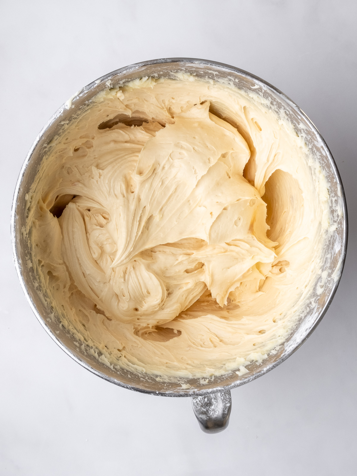 Image shows step 3 of how to make caramel cream cheese frosting for this peppermint crisp cupcake recipe.