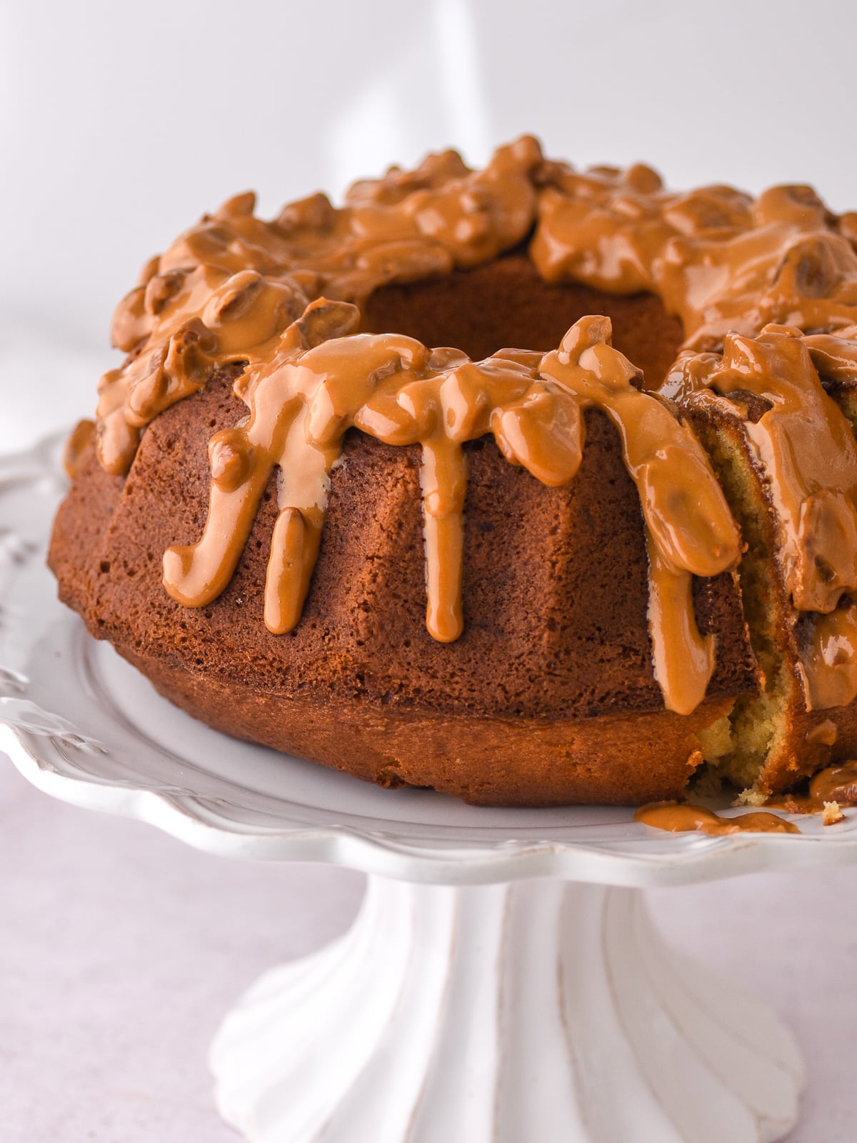 Image shows Banana Bundt Cake with Sour Cream on a white cake stand.