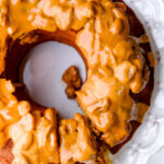 Banana bundt cake with sour cream shown from above. You can see the caramel and pecan sauce dripping off the cake.