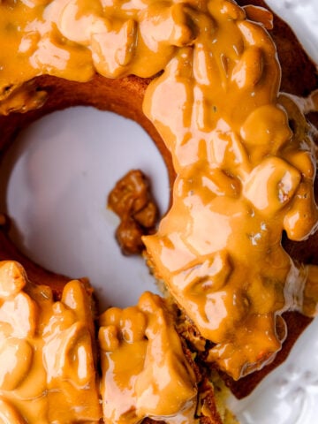 Banana bundt cake with sour cream shown from above. You can see the caramel and pecan sauce dripping off the cake.