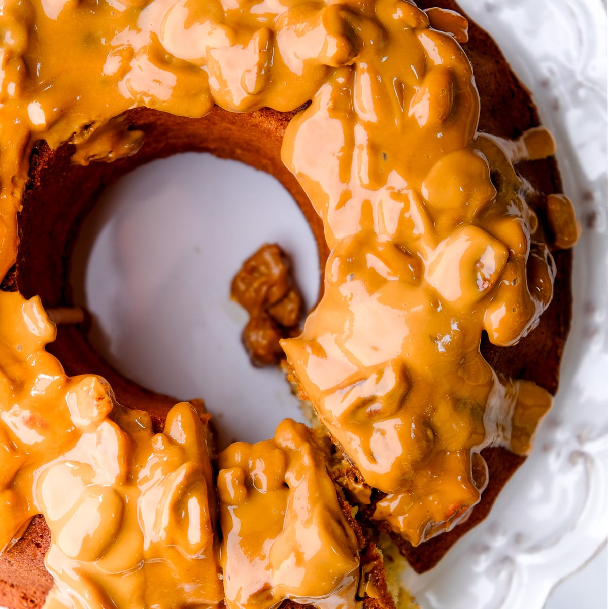 Banana bundt cake with sour cream shown from above. You can see the caramel and pecan sauce dripping off the cake.