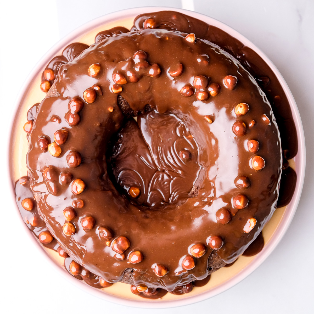 Chocolate Nut Bundt Cake shown from above you can see the chocolate and nut sauce dripping off the cake.