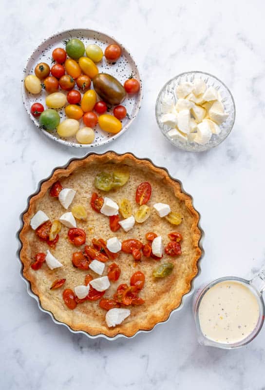 Burrata Cheese and Tomato Quiche  being made, all the ingredients for the filling laid out 