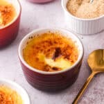 Ramekins filled with white chocolate creme brulee shown on a kitchen counter.