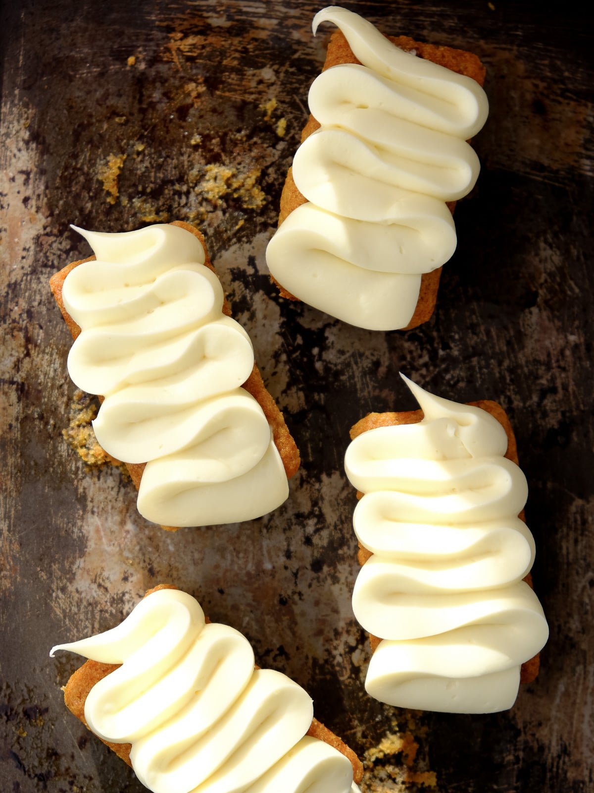 Image shows step 4 of how to make cream cheese frosting for mini carrot cakes.