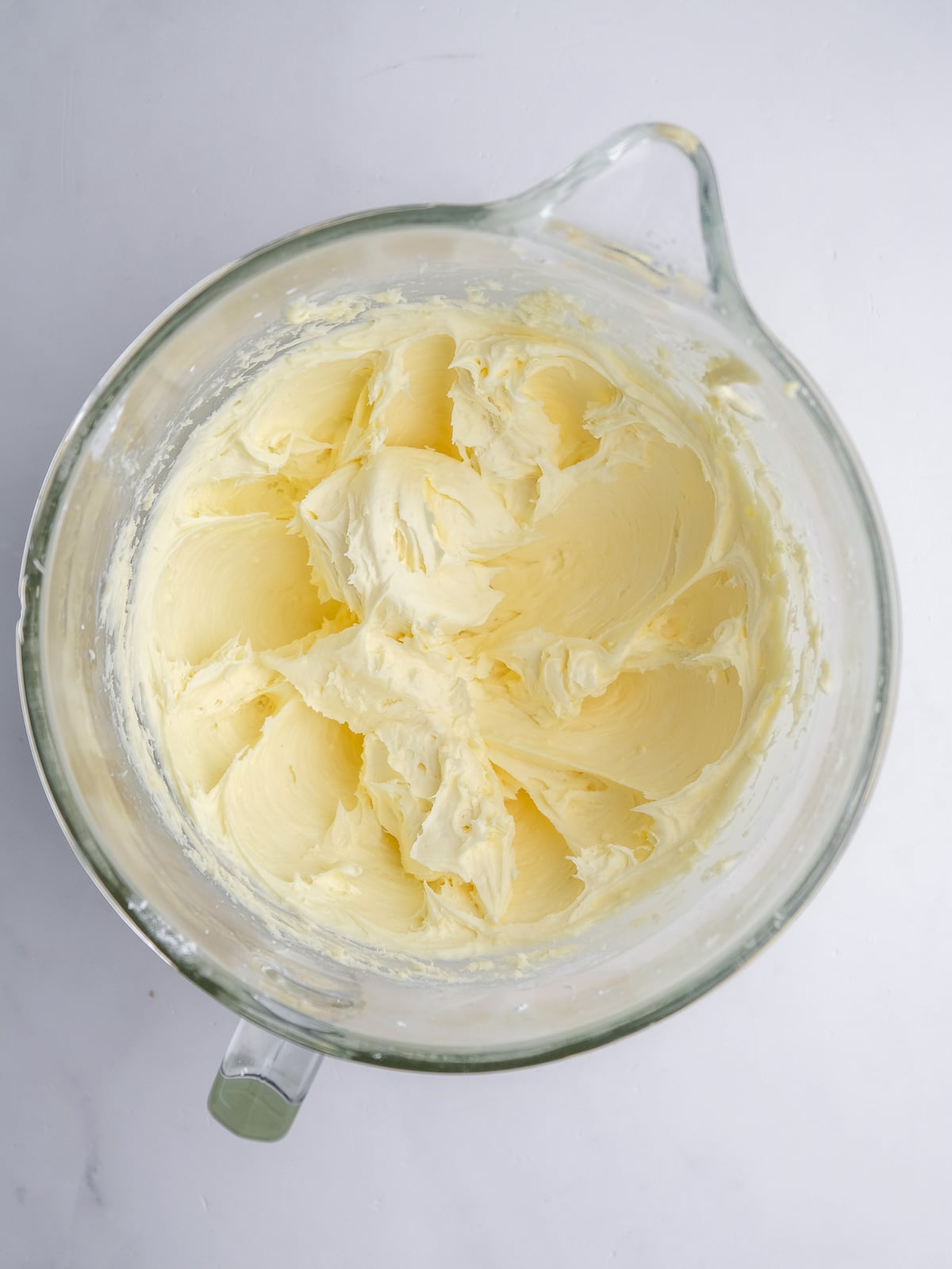 Image shows step 3 of how to make cream cheese frosting for mini carrot cakes.