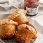 Jumbo Mac & Cheese Muffins shown on a plate next to jam
