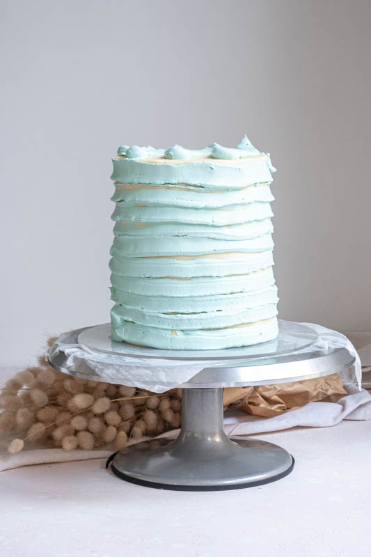 How to Make a Baby Shower Cake for a Boy - final steps of smoothing and colouring the cake 