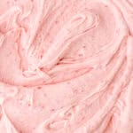 Raspberry Buttercream shown up close swirled on a surface.