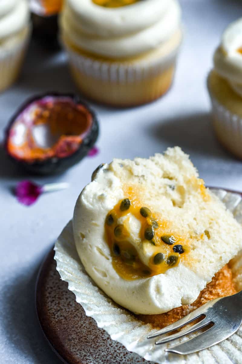 Passionfruit Cupcake on a plate cut in half.