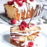White Chocolate and Raspberry Loaf Cake slice on a plate with a fork.