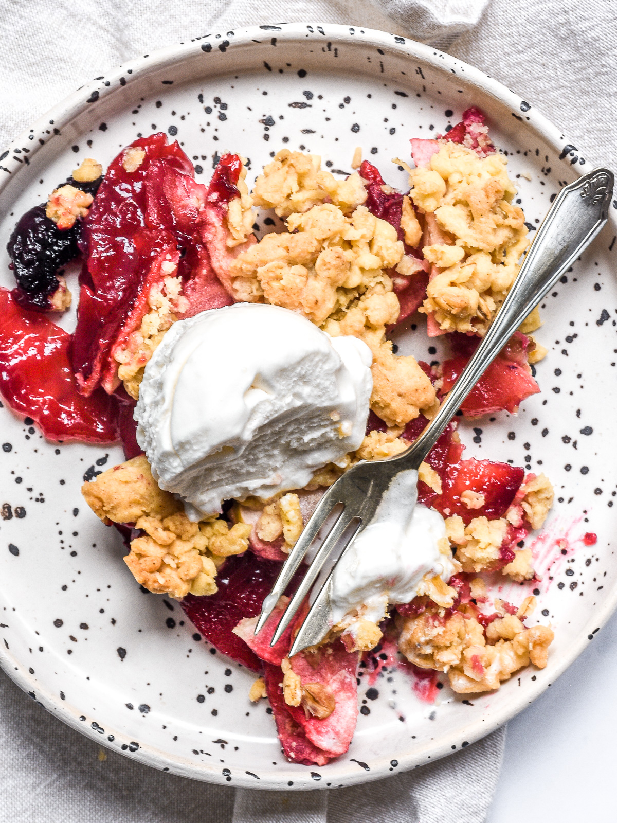 Apple and Blackberry Crumble shown on a plate from above.