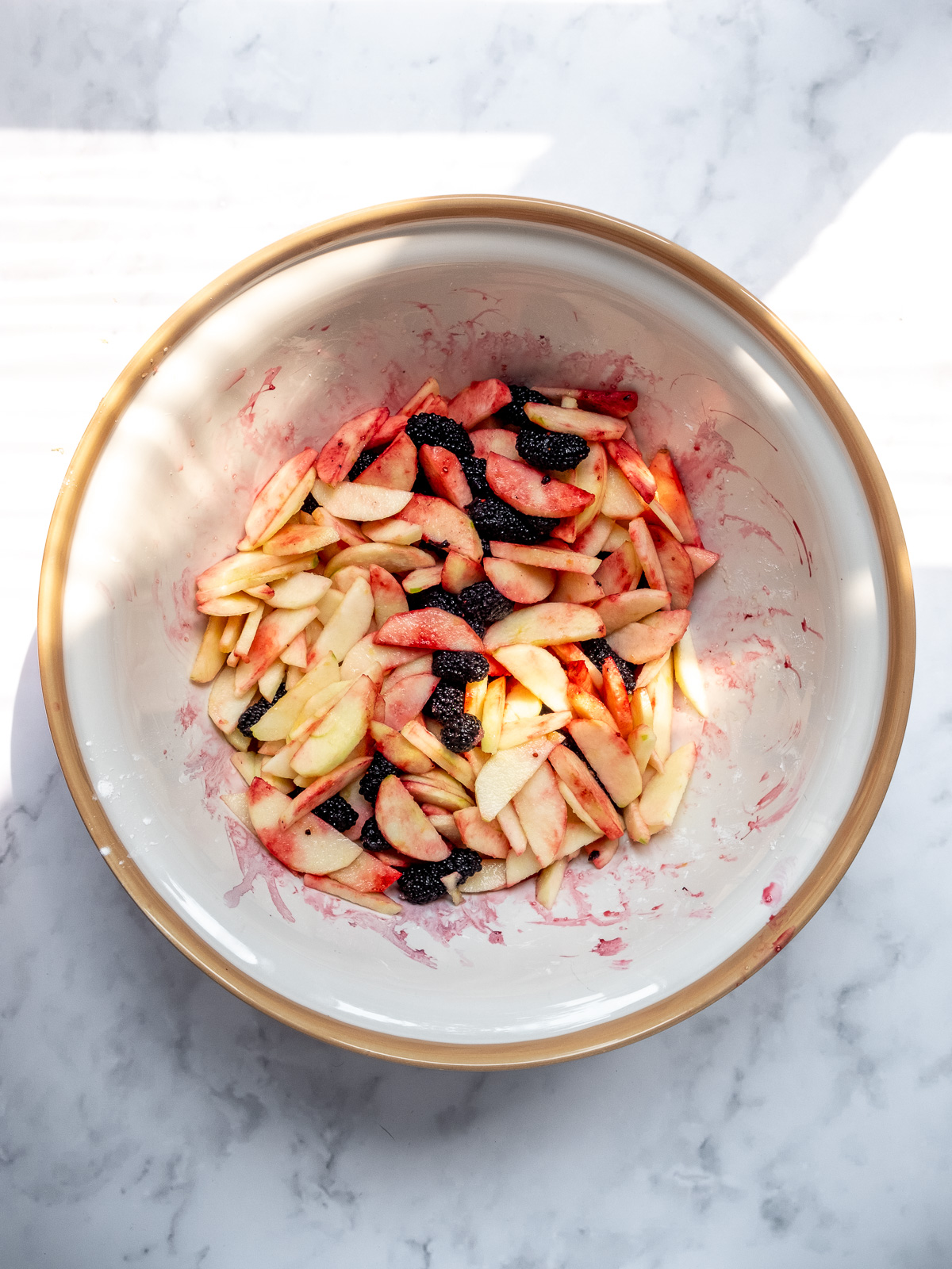 Image shows step 5 of how to make apple and blackberry crumble: the apple and blackberry filling.