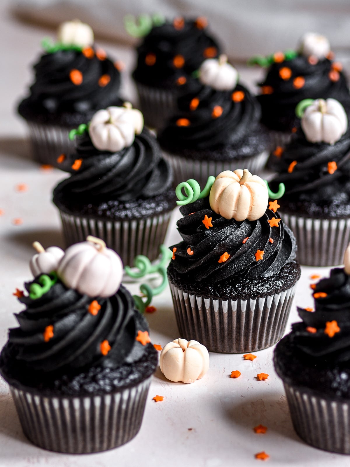 Image shows Black Velvet Halloween Cupcakes with Black Buttercream Frosting on a counter top.