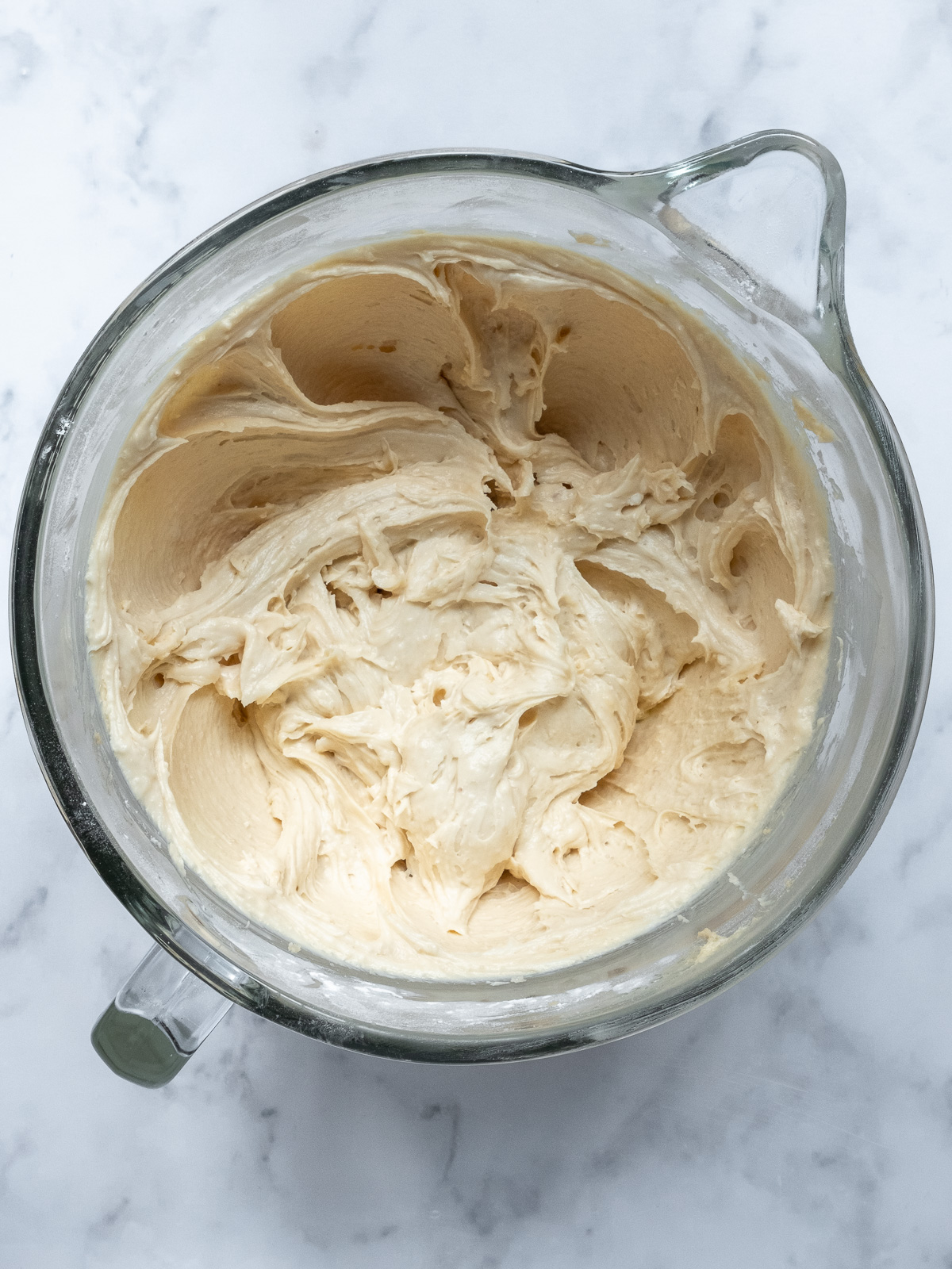 Image shows step 3 of how to make brown sugar cream cheese frosting for a pumpkin and carrot cake.