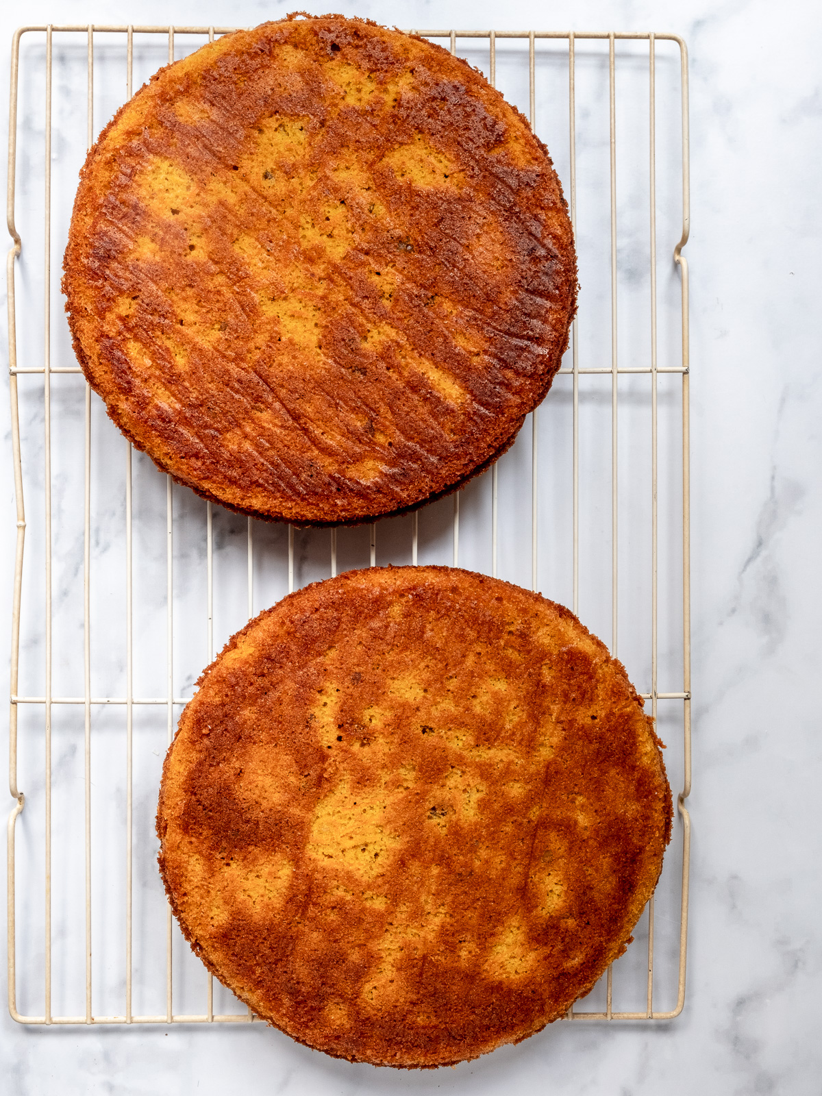 Image shows pumpkin carrot cake ready to be decorated with brown sugar cream cheese frosting.