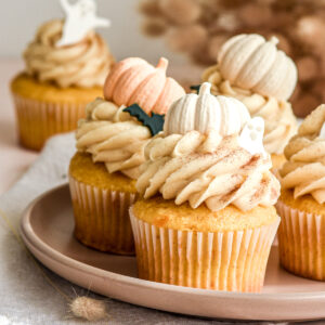 Pumpkin Halloween Cupcakes with Brown Sugar Cream Cheese Frosting shown on a small plate on a kitchen counter.