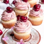 Cherry Cupcakes on a counter with flowers.