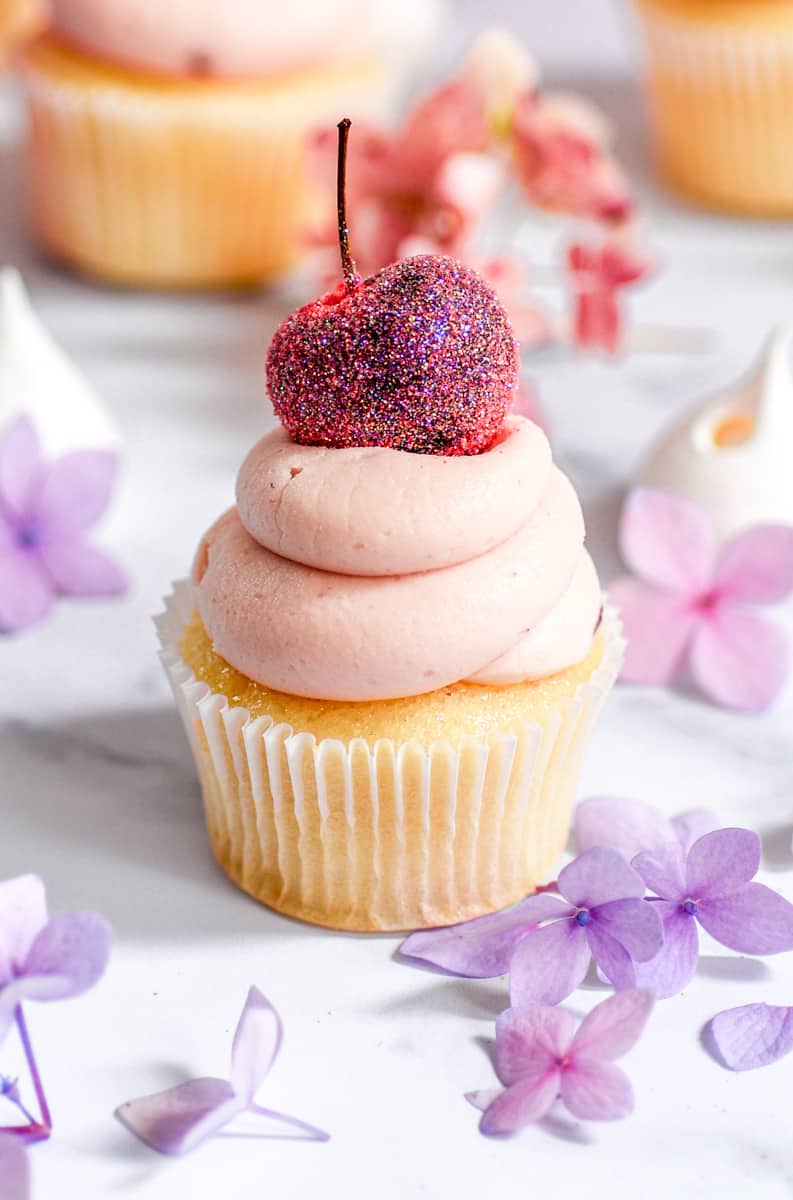 Cherry Frosting shown on a vanilla cupcake.