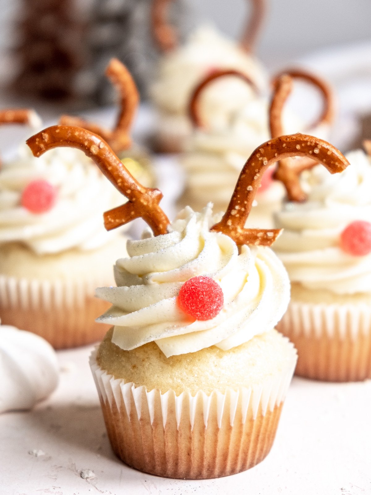 Vanilla reindeer cupcakes shown decorated on a kitchen counter.