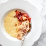 Nectarine Crumble in a white plate with custard and a fork