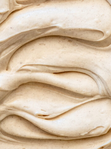 Image shows Cinnamon Cream Cheese Frosting from up close so you can see the smooth texture of the frosting.