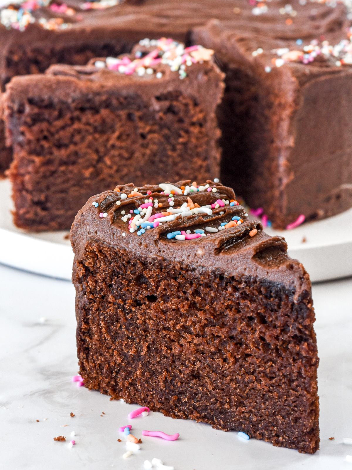 A slice of mini chocolate cake shown, you can see the moist fluffy texture of the cake.