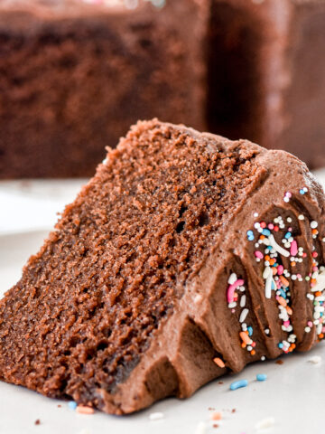 A slice of mini chocolate cake decorated with sprinkles shown on it's side.