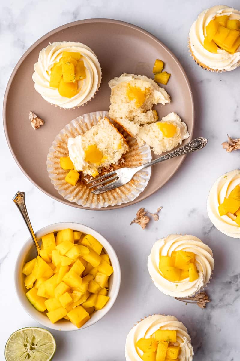 Mango Cupcakes shown from above on a marble background.