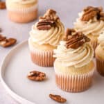 Pecan Pie Cupcakes shown on a white plate on a kitchen counter.
