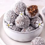 Condensed Milk Truffles shown in a white bowl with small white flowers.