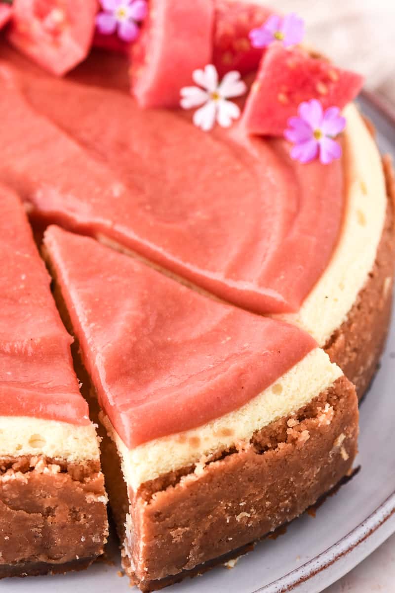 Guava Cheesecake shown from up close, you can see a slice of cheesecake that is cut about to be served.