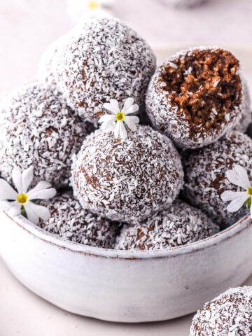 Condensed milk chocolate truffles covered in coconut shown in a small bowl.