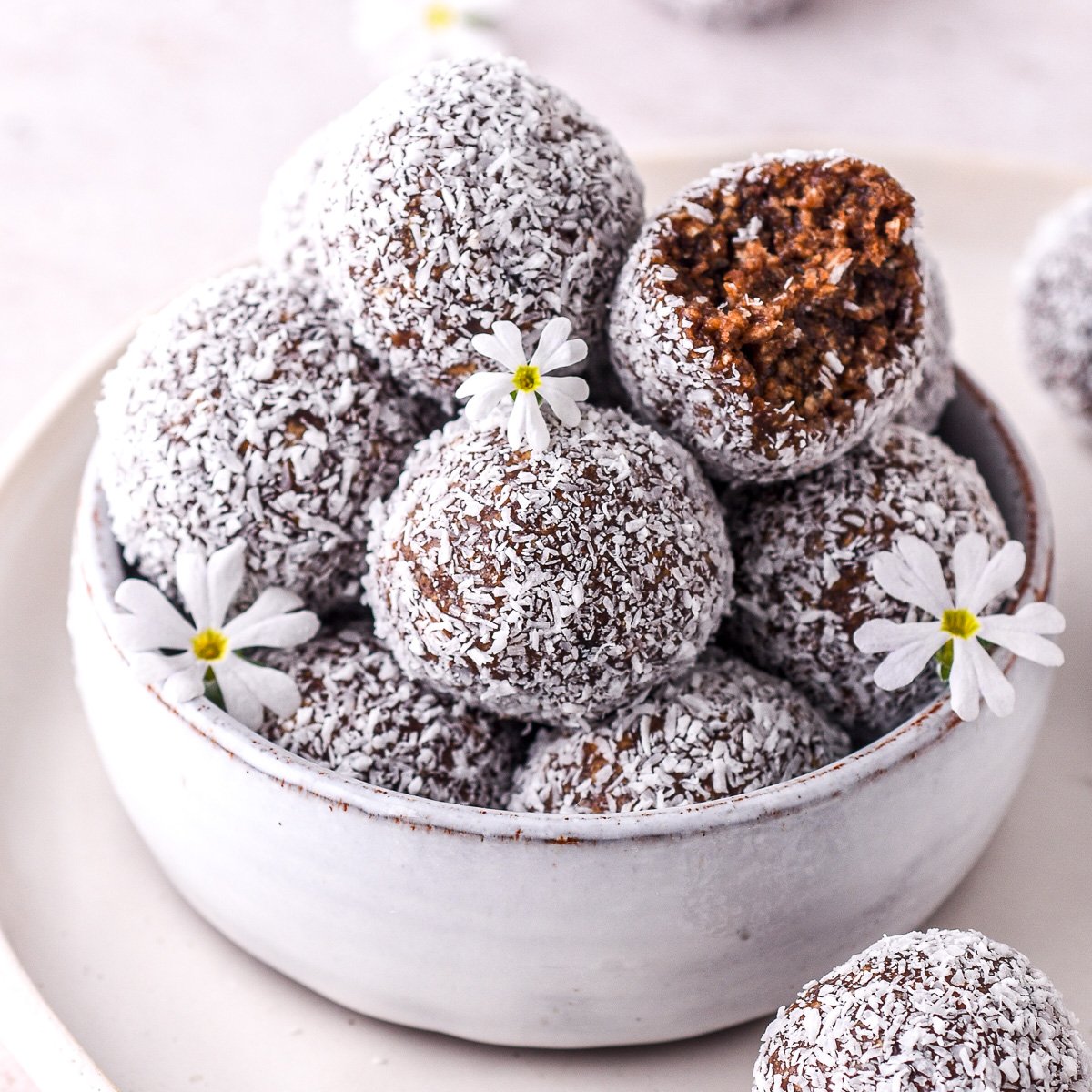 Condensed milk chocolate truffles covered in coconut shown in a small bowl.