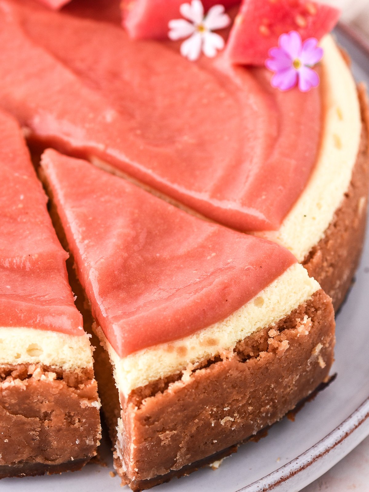 Image shows cheesecake from above with a slice cut.
