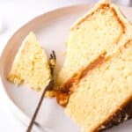 Salted Caramel Cake slice shown on a plate with a fork through the cake