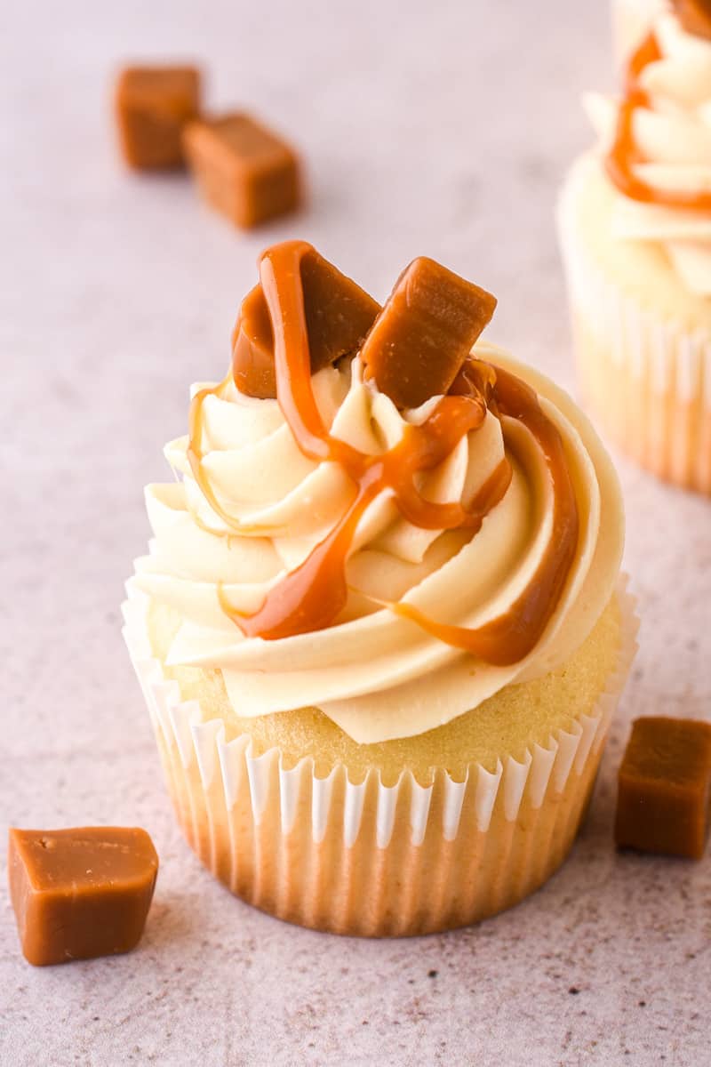 Caramel Filled Cupcake shown up close, you can see the caramel drip and caramel pieces on the cupcake.