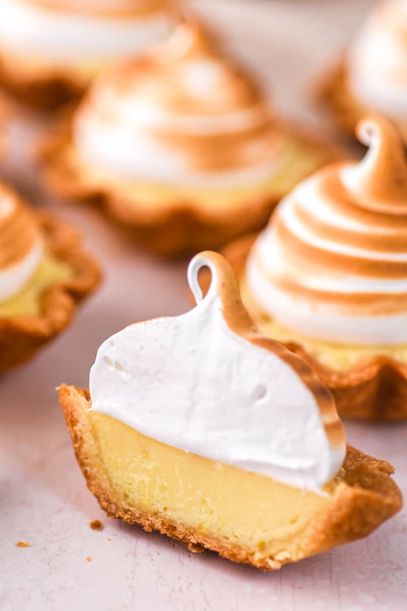Photos shows mini lemon meringue pies, there is one in front that has been cut in half/