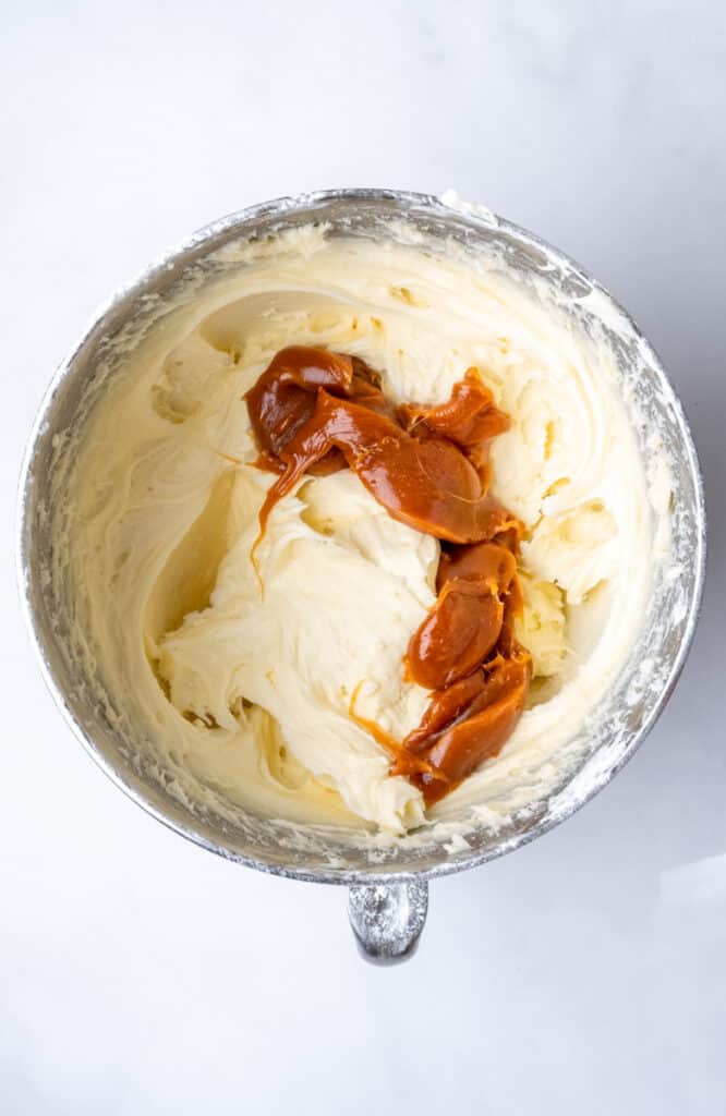 Image showing step 3, after the cream cheese has been added. You can see the caramel in the bowl before it has been mixed into the frosting. 