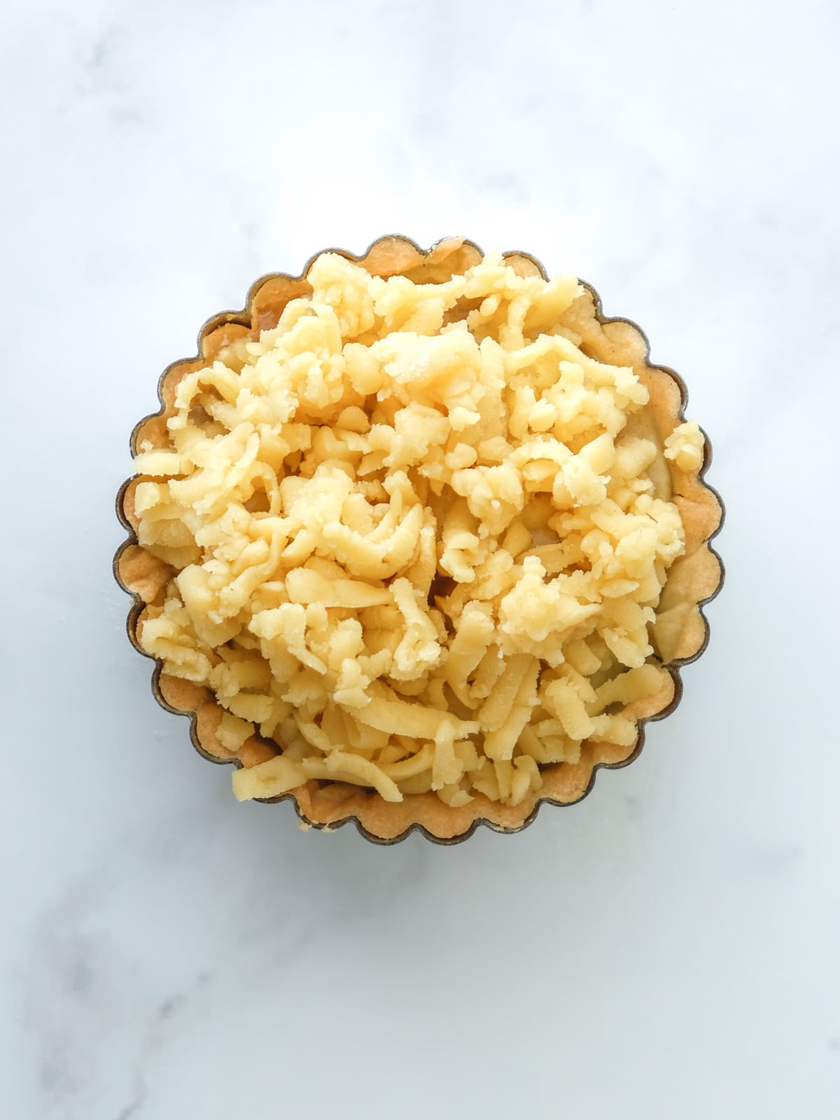 Image shows step 4 of how to make the spiced apple filling for apple crumble tarts.