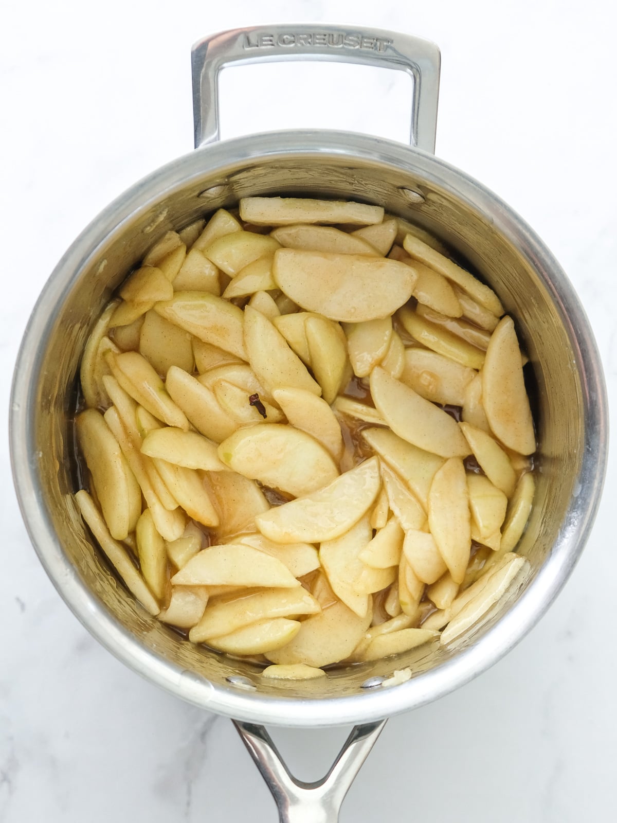 Image shows step 2 of how to make the spiced apple filling for apple crumble tarts.