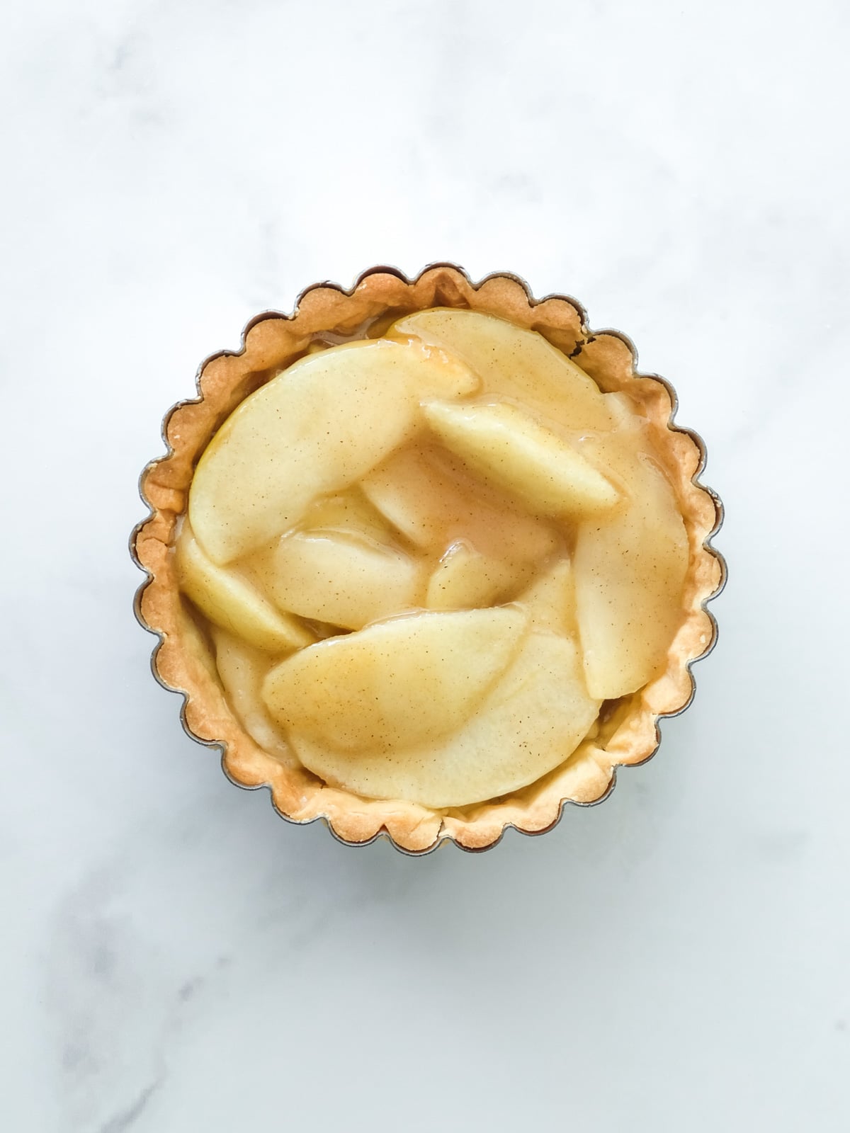 Image shows step 3 of how to make the spiced apple filling for apple crumble tarts.
