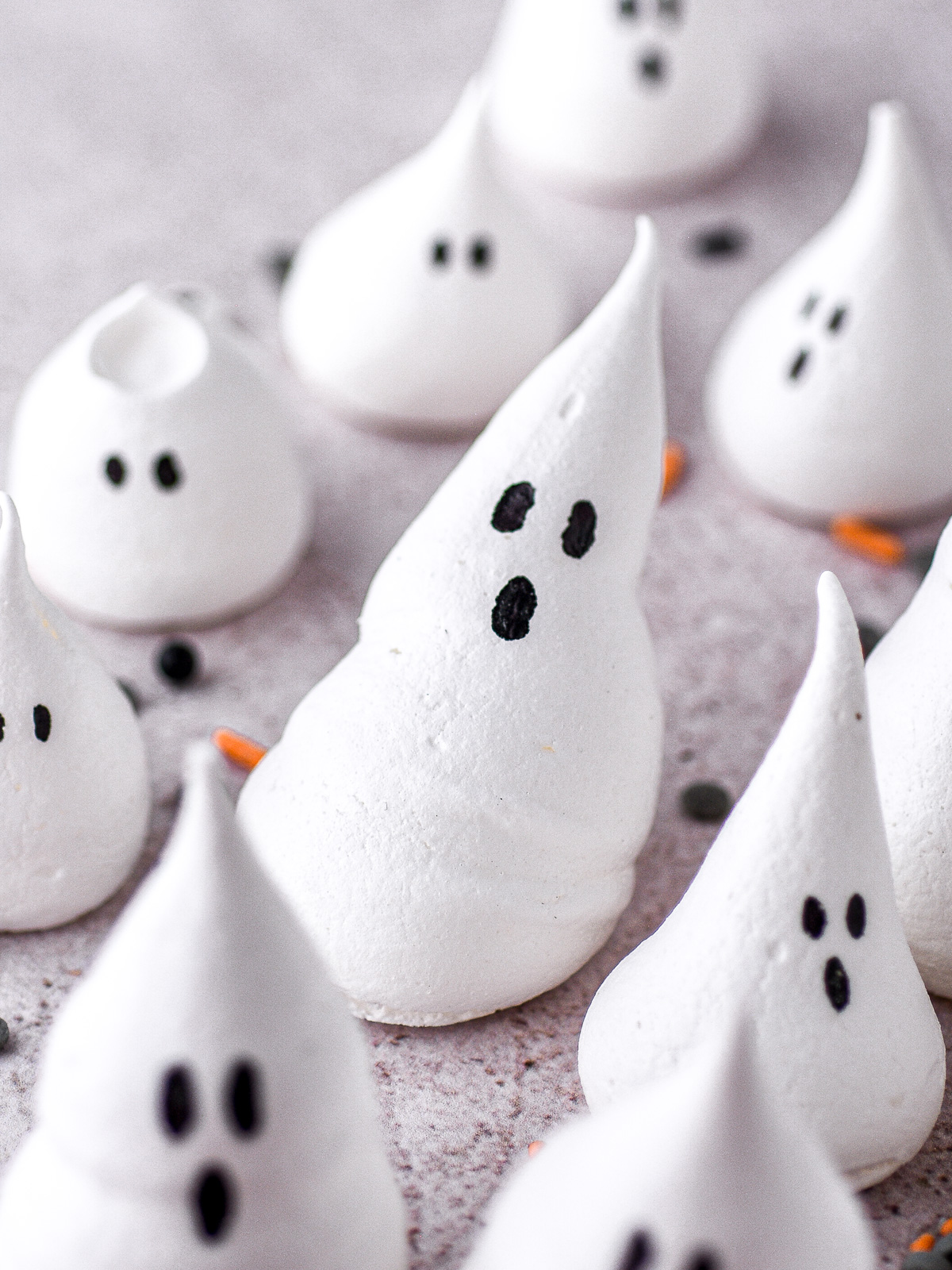 Image shows different sized Halloween ghost meringues on a counter.