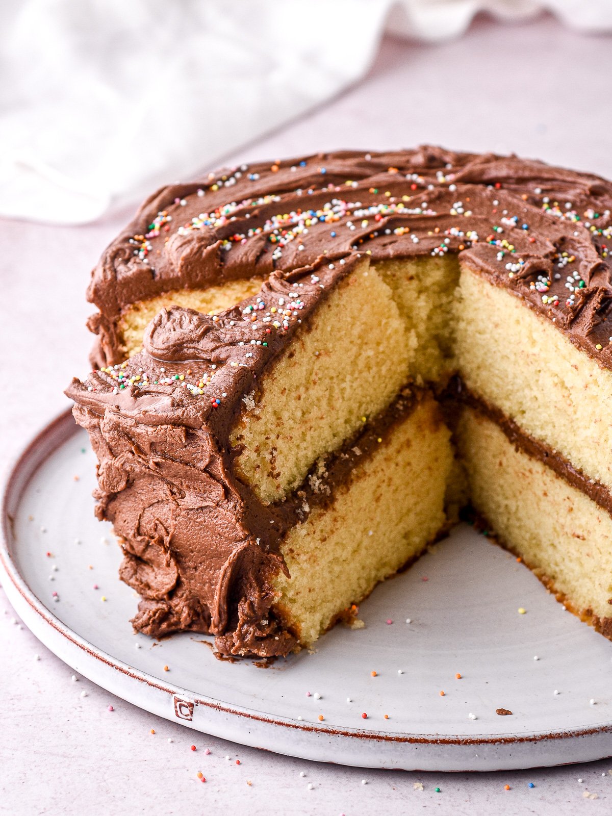 Image shows cake on a plate with some slices cut and removed so that you can see the insides of the cake.