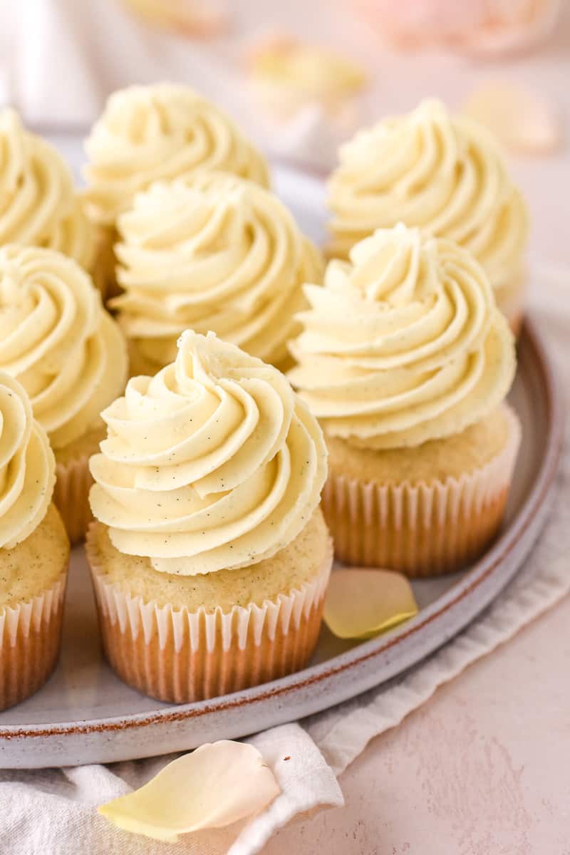 Vanilla Bean Cupcakes shown on a plate set on top of a kitchen counter.