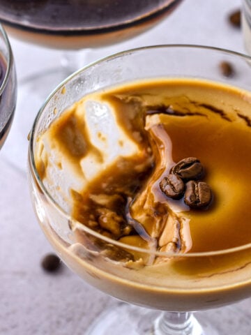 Espresso Panna Cottas shown from above, the one panna cotta has a spoonful of the dessert missing.