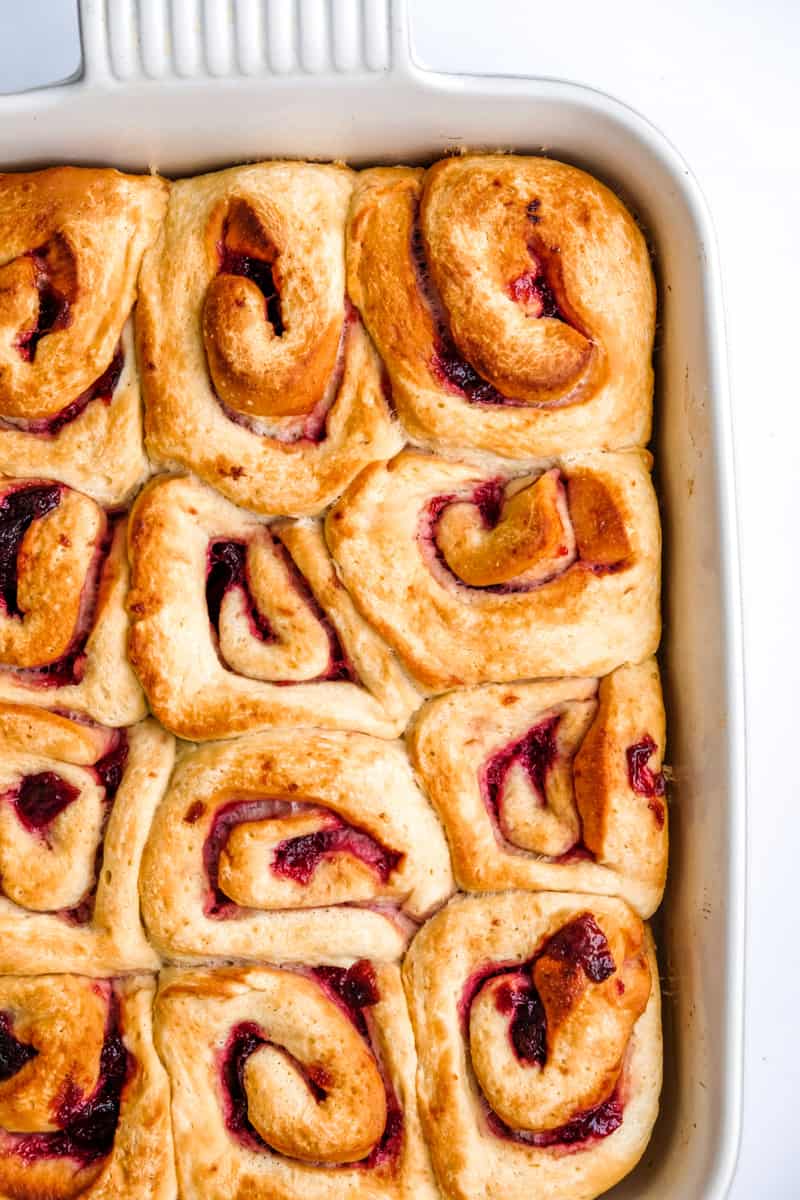 Cherry Cinnamon Rolls shown in their baking dish as they have come out of the oven and before the frosting has been smoothed over. 