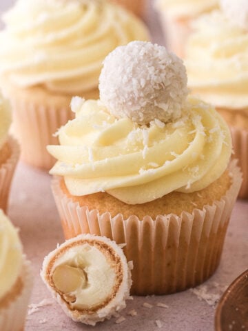 Decorated Raffaello cupcakes shown on a counter.