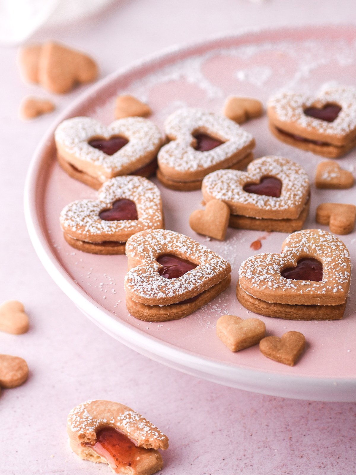 Image shows decorated cookies on a pink cake stand.